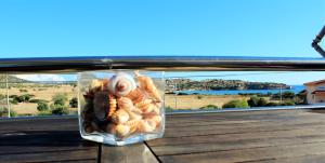 a container of shellfish on a balcony with a view at Helen's Sounio Apartments in Sounio