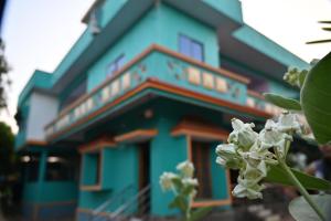a blue building with a flower in front of it at Ramleela Stay, Gokarna in Ankola