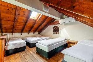 three beds in a room with wooden ceilings at Jacob Ha-Tzayadim in Geʼullim