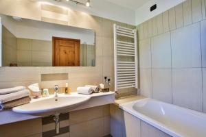 ein Badezimmer mit Waschbecken, Badewanne und Spiegel in der Unterkunft Ellex Eco Hotel in Gressoney-la-Trinité + 30 Fotos
