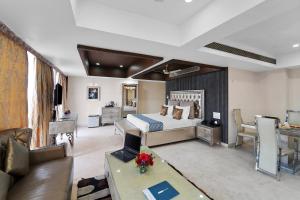 a bedroom with a bed and a living room at Palette Orient Hotel & Convention Centre by CheckIn, Nagpur in Nagpur +58 photos