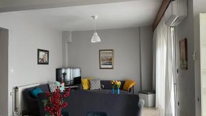 a living room with a couch and a tv at rodou 39 apartment in Alexandroupoli