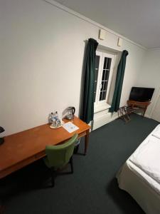 a hotel room with a desk and a bed and a bedroom at Möckelsnäs Herrgård in Diö