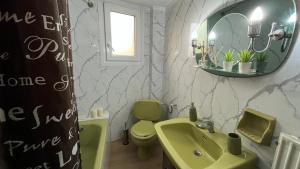 a bathroom with a green sink and a mirror at rodou 39 apartment in Alexandroupoli +40 photos