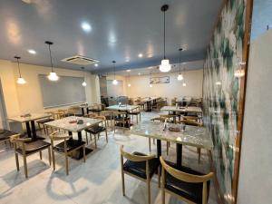 a dining room with tables and chairs and a chalkboard at Hotel M Plaza New Digha in Digha