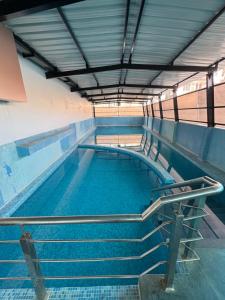 a swimming pool with stairs in a building at Hotel M Plaza New Digha in Digha