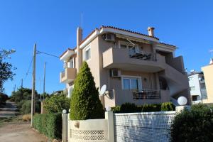 a house with a fence in front of it at Helen's Sounio Apartments in Sounio