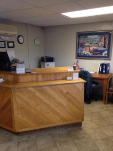 un bureau dans un bureau avec une personne assise à un comptoir dans l'établissement Mount Blue Motel, à Farmington