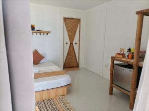 a small bedroom with a bed and a closet at Ocam Ocam Bayside Lodge in Busuanga