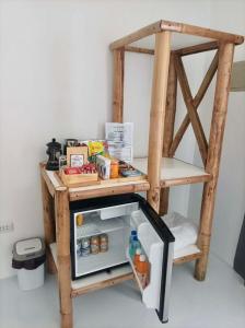 a small wooden table with an open refrigerator at Ocam Ocam Bayside Lodge in Busuanga