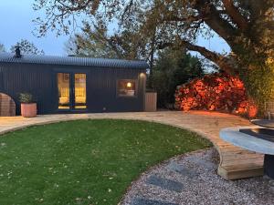 a backyard with a small black house with a grass yard at Acorn Hideaway in Canterbury