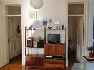 a living room with a tv on a wooden entertainment center at The Bleu Lisbon Flat in Lisbon