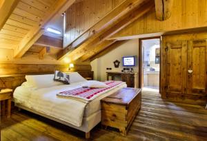 ein Schlafzimmer mit einem Bett in einem Zimmer mit Holzwänden in der Unterkunft Ellex Eco Hotel in Gressoney-la-Trinité