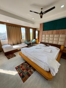 a bedroom with a large bed and a large window at Hotel M Plaza New Digha in Digha