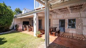 a patio of a house with a table and a bench at Griki in Paternoster