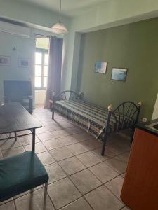 a bedroom with a bed and a table and chairs at Zannikos Rooms in Ermoupoli