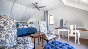 a bedroom with a bed and a desk and a chair at Griki in Paternoster