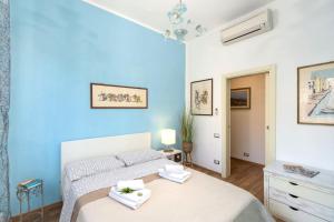 a bedroom with a bed and a blue wall at Casamia Tuscan Oasis 4Br Panoramic Penthouse Hot Tub & Easy Parking in Siena