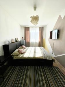 a bedroom with a bed and a television in it at Sunny View 2BR Apartment with Terrace - near VIVO and Amethyst in Floreşti