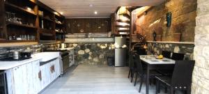 a kitchen with a stove and a table with chairs at The Zephyr House -2- in Pyrgos