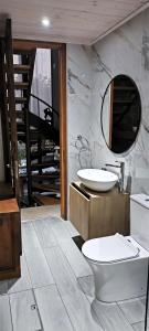 a bathroom with a sink and a toilet and a mirror at The Zephyr House -2- in Pyrgos +3 photos