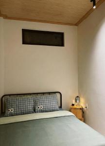 a bedroom with a bed and a wall at Êm Êm Homestay Đảo Lý Sơn in Ly Son