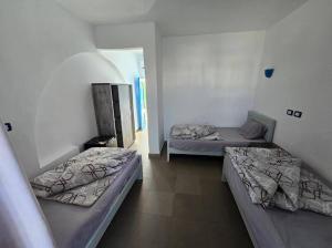 a room with three beds in a room at Balsam hotel in Dahab
