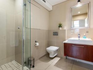 a bathroom with a toilet and a sink and a shower at 167 Eden on the Bay in Big Bay +19 photos