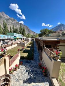 a pathway leading to a building with mountains in the background at Zimsa Resort Skardu in Skardu