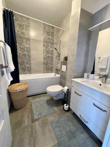 a bathroom with a tub and a toilet and a sink at Sunny View 2BR Apartment with Terrace - near VIVO and Amethyst in Floreşti +23 photos
