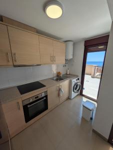 a kitchen with wooden cabinets and a sink and a dishwasher at Hamaca & Sea in Cartagena +6 photos