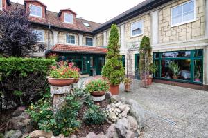 ein Haus mit Topfpflanzen davor in der Unterkunft Hotel Aragon in Ahrensfelde
