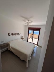 a white bedroom with a bed and a window at Hamaca & Sea in Cartagena