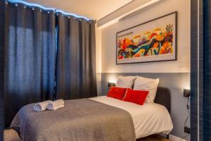 a bedroom with two beds with blue curtains and red pillows at Slate at Max, Luxury in Mulhouse, Air Conditionné in Mulhouse