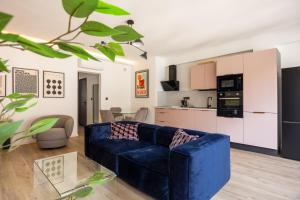 a living room with a blue couch and a kitchen at Slate at Max, Luxury in Mulhouse, Air Conditionné in Mulhouse