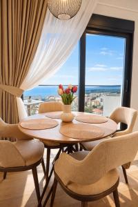 a dining room with a table and chairs and a window at Olive apartments in Petrovac na Moru