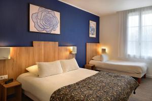 a hotel room with two beds and blue walls at Logis Hôtel Maison Voltaire in Amboise