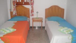 a bedroom with two beds and a side table at Casa El Pino in Mogán