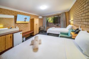 a hotel room with a bed and a tv at Cambridge Motel in Mitchell