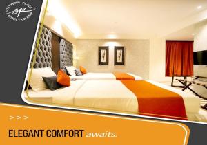 a hotel room with two beds and a tv at Southern Plaza in Kolkata