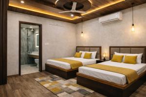 two beds in a hotel room with a bathroom at Hotel PKD Vrindavan Near 100 Futta Main Road in Vrindāvan