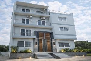 a tall white building with stairs in front of it at Hotel PKD Vrindavan Near 100 Futta Main Road in Vrindāvan