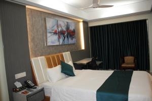 a bedroom with a bed with a painting on the wall at City Inn Ltd in Khulna