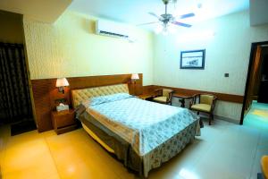 a hotel room with a bed and two chairs at City Inn Ltd in Khulna