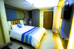a bedroom with a bed and a flat screen tv at City Inn Ltd in Khulna