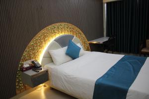 a bedroom with a bed with an arch headboard at City Inn Ltd in Khulna