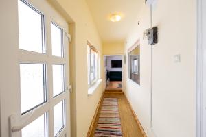 a hallway with a door and a rug at Menasagi Sit&Dream Cottage in Menasag-Ujfalu