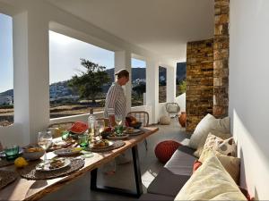 a person standing in a room with a table with food at Olive Tree Homes in Ios Chora