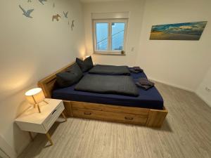 a bedroom with a bed with blue sheets and a window at Ferienwohnungen Wassergrundstück Malchow in Malchow