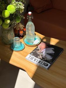 a table with a bottle and a magazine and a book at Êm Êm Homestay Đảo Lý Sơn in Ly Son